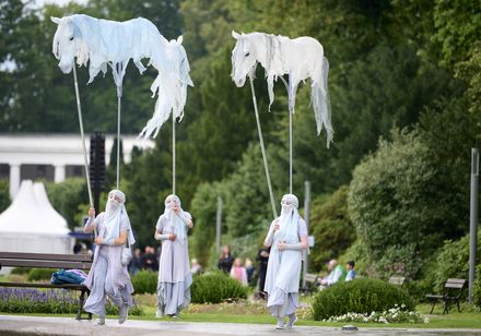 Darsteller tragen weiße Himmelspferde-Figuren bei der Griechischen Nacht der Parklichter 2025 im Kurpark Bad Oeynhausen.