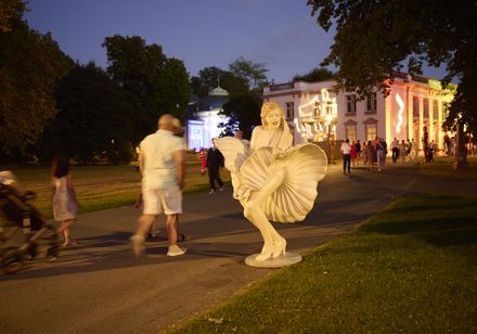 Statue im Stil einer berühmten Filmszene vor illuminiertem Gebäude bei den Parklichtern 2022 im Kurpark unter dem Motto „Unforgettable – die größten Film- und Musicalhits“.
