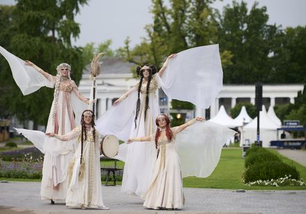 Vier als griechische Musen gekleidete Künstlerinnen treten vor der Mittelfontäne im Kurpark Bad Oeynhausen bei den Parklichtern 2025 auf.