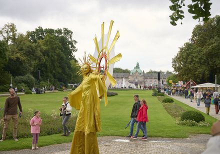 Gold kostümierter Künstler als Sonnengott Helios bewegt sich durch den Kurpark Bad Oeynhausen bei den Parklichtern 2025.