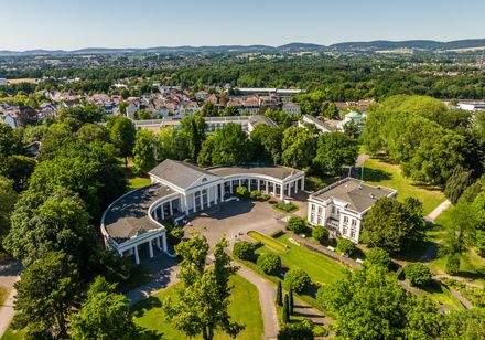 Kurpark Bad Oeynhausen mit Wandelhalle und Tourist Information, Stadtpanorama und Wiehengebirge im Hintergrund