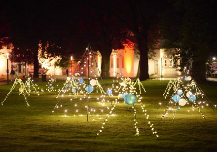 Blau-weiß beleuchtete Lampignons auf einer Wiese im Kurpark Bad Oeynhausen bei den Parklichtern 2025 zur Griechischen Nacht.