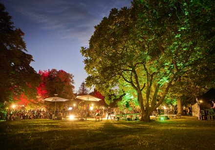 Illuminierter Kurpark mit Bühne und Publikum bei den Parklichtern 2022 unter dem Motto „Unforgettable – die größten Film- und Musicalhits“.