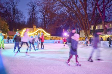 Eislaufbahn mit Schlittschuh laufenden Kindern auf dem Inowroclaw-Platz in der Innenstadt von Bad Oeynhausen zum Weihnachtsmarkt.
