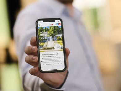 Ein Smartphone mit der neuen Website vom Staatsbad wird präsentiert