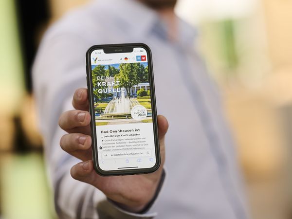 Ein Smartphone mit der neuen Website vom Staatsbad wird präsentiert