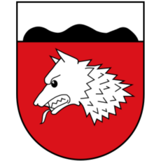 Stadtwappen von Wulferdingsen mit silbernem Wolfskopf auf rotem Grund und schwarzem Dreiberg im silbernen Schildhaupt
