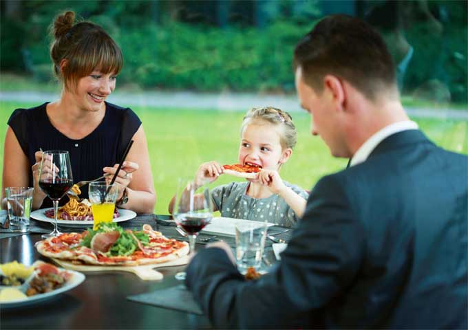 Familie isst Pizza im Restaurant Leander