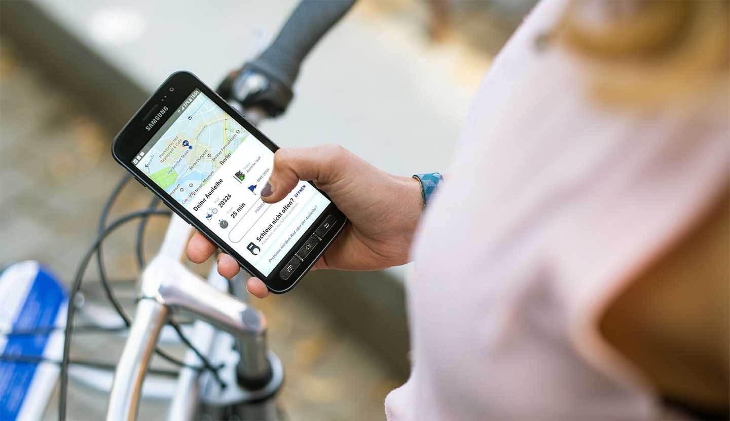 Frau leiht Fahrrad mit App aus
